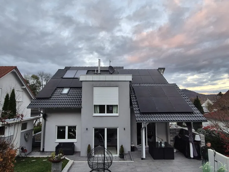 Einfamilienhaus mit Photovoltaikanlage unter Abendhimmel