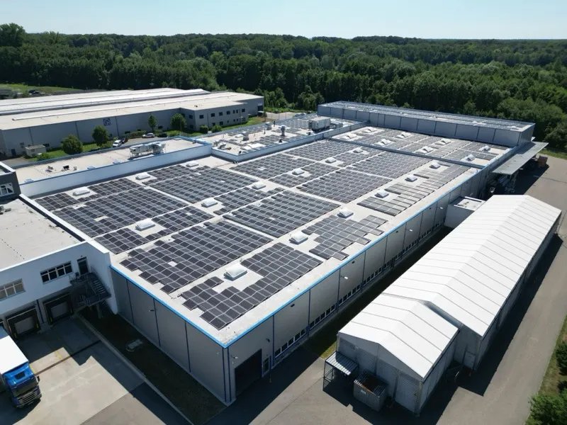 Luftaufnahme einer großen Photovoltaikanlage auf einem Gewerbekomplex