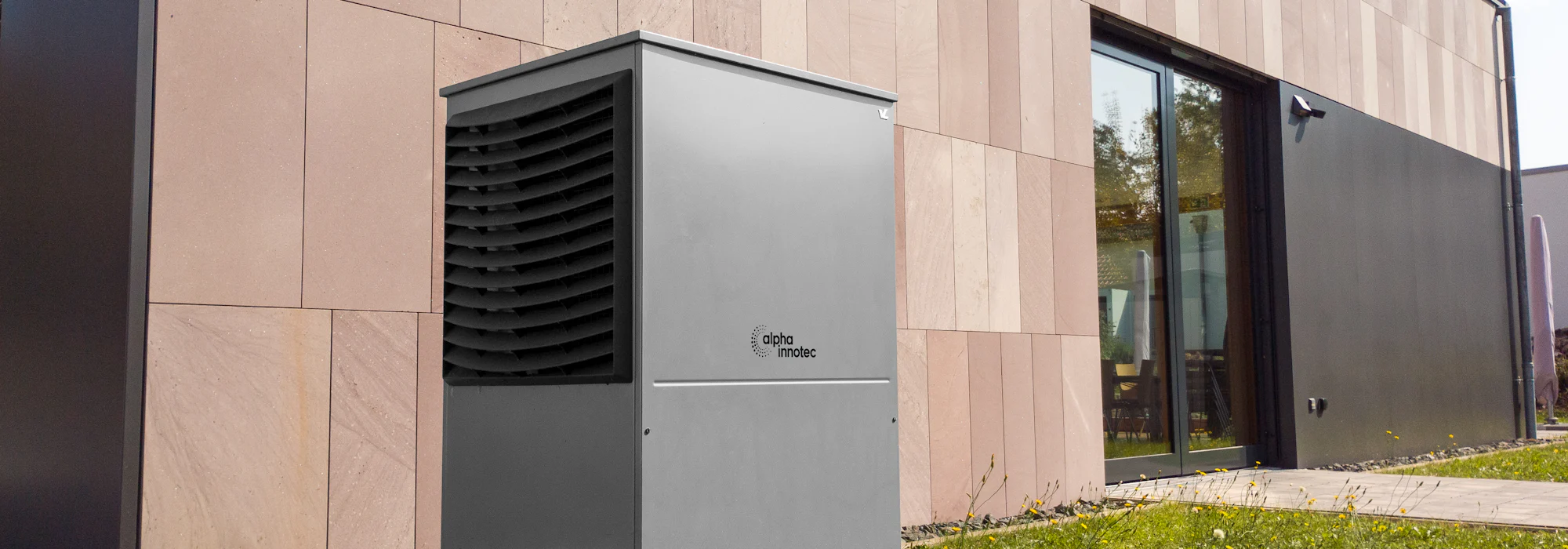 Wärmepumpe an der Außenwand eines modernen Wohnhauses